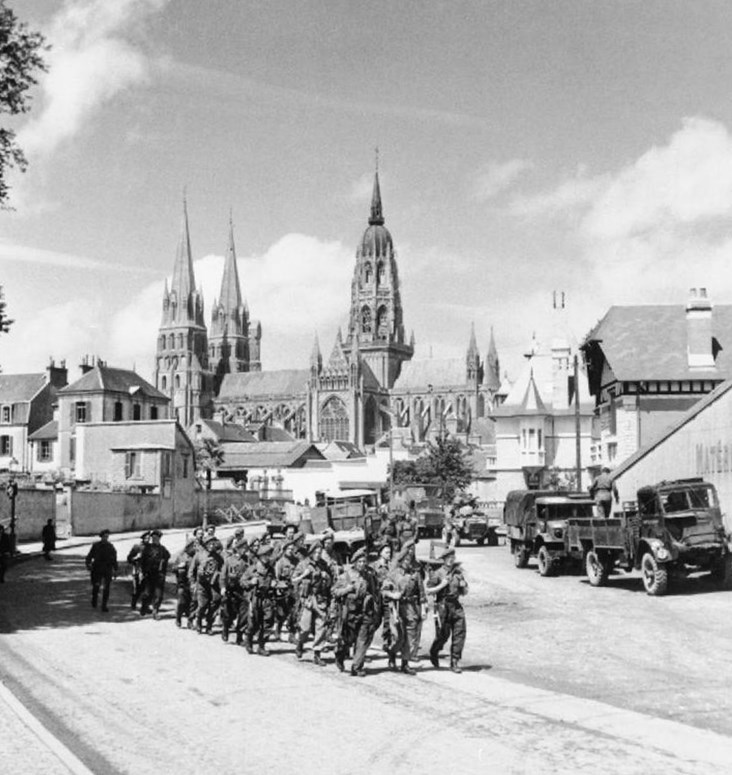 Photo: British Troops March Through Freed Bayeux.